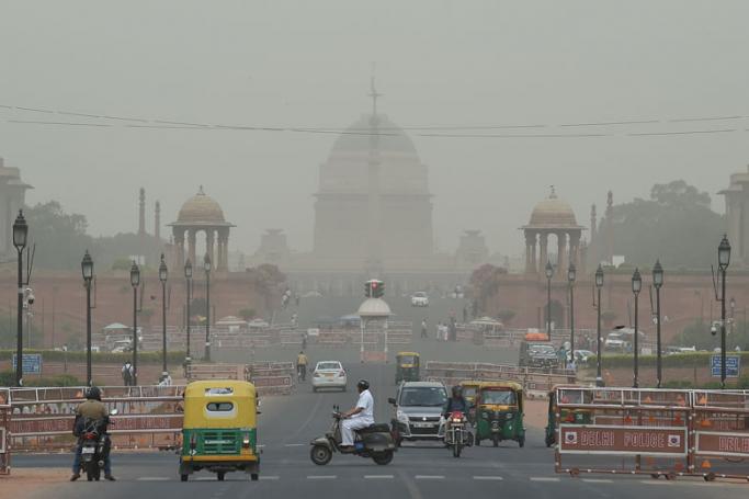 Vehicles pass by the Indian President house as dust covers the skyline in New Delhi. Photo: AFP