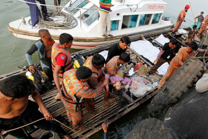 (Warning: Graphic content) Rescue workers recover the body of a child after a ferry capsized in the Padma river near Manikganj, Bangladesh, February 22, 2015. Photo: EPA. 
