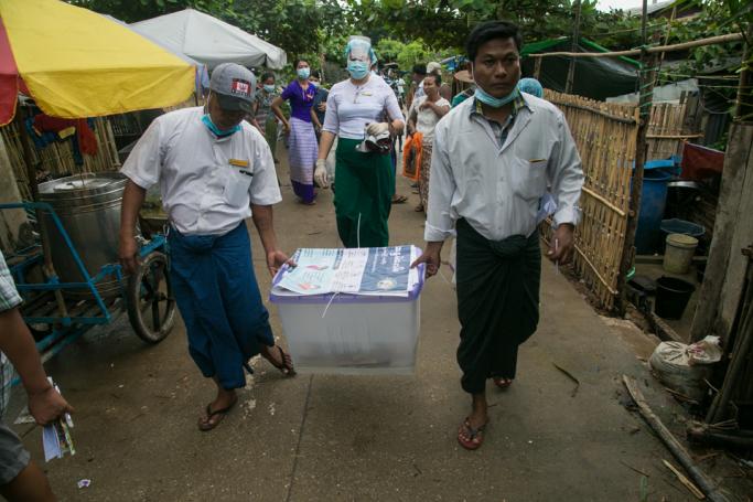  Election officials carry a ballot box at a village in Yangon on October 31, 2020, during advance voting for elderly people ahead of Myanmar's November 8th general election. Photo: Sai Aung Main / AFP