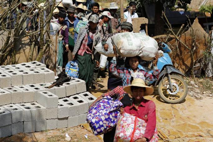 People carry their belongings as they flee from the Kokang capital Laukkai, northern Shan State, Myanmar, February 17, 2015. Photo: Lynn Bo Bo/EPA
