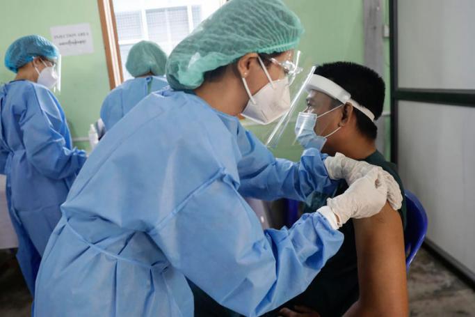 A health worker (R) receives a dose of Covishield Covid-19 vaccine at Yangon General Hospital, in Yangon, Myanmar, 27 January 2021.