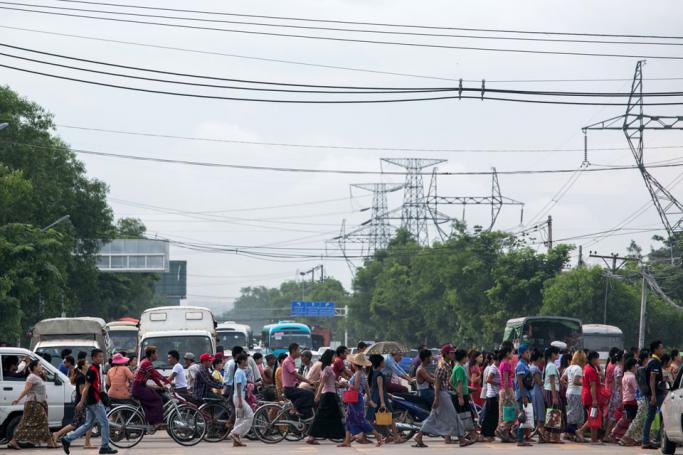People walk and cycle to factories in Hlaing Tharyar township on the outskirts of Yangon on June 26, 2019. Photo: Sai Aung Main/AFP