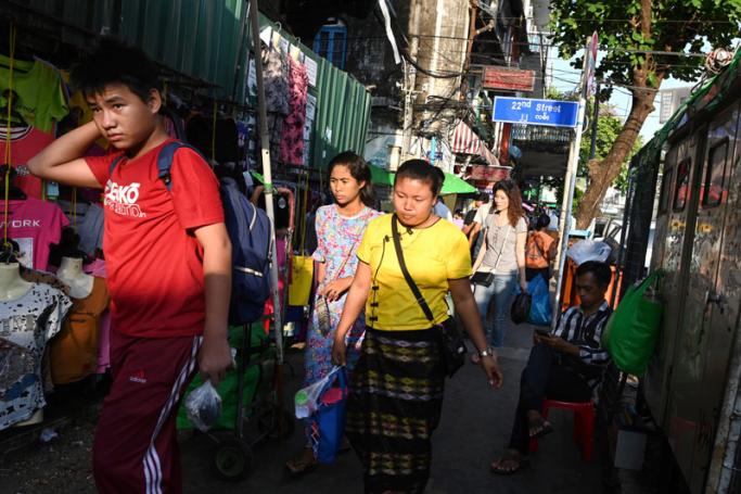 People walk along rows of sidewalk shops in Yangon. Photo: Ye Aung Thu/AFP