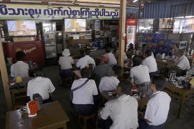 Customers at a coffee shop in Yangon watch a live television broadcast. Photo: AFP
