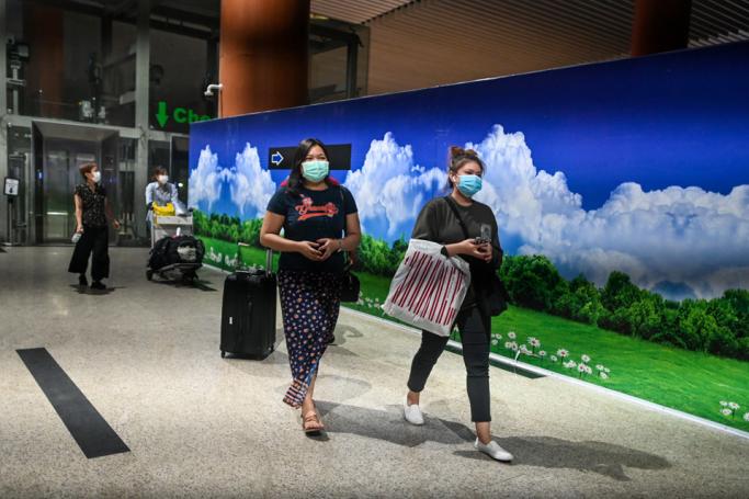 People wear facemasks amid concerns of the spread of the COVID-19 coronavirus while walking at Yangon international airport in Yangon on March 18, 2020. Photo: Ye Aung Thu/AFP