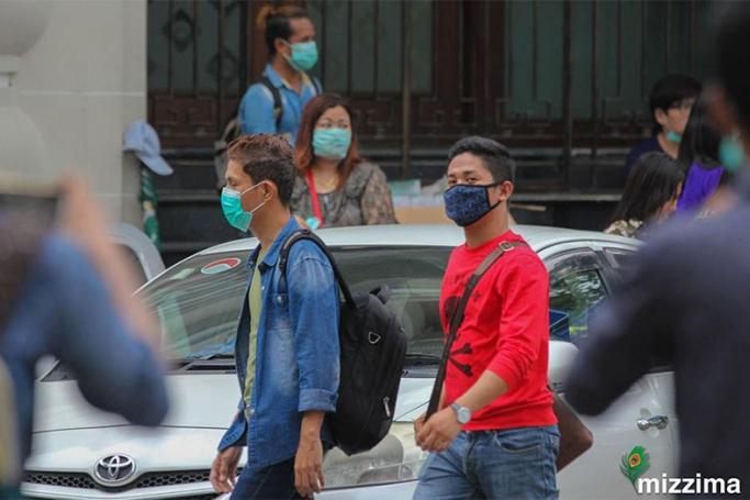 People wear masks as they walk in the downtown area in Yangon on 24 July 2017. Photo: Thura/Mizzima
