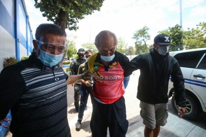 Ruben Ecleo is escorted by officers outside police regional headquarters in Manila, following his arrest (AFP Photo/STR) 