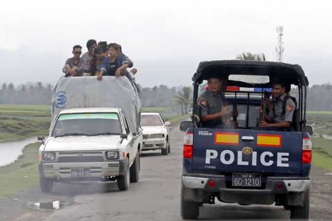People travel by car as police vehicle drive pass in Maungdaw township, Rakhine State, western Myanmar, 07 September 2017. Photo: Nyein Chan Naing/EPA-EFE
