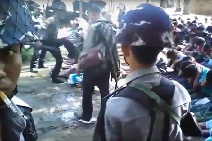 This file screen grab taken on January 4, 2017 from a YouTube video originally taken by Myanmar Constable Zaw Myo Htike (pictured at far L - looking at camera) shows a policeman (back L) kicking out at a Rohingya minority villager seated on the ground with others, in the village of Kotankauk during a police area clearance operation on November 5, 2016. Photo: Zaw Myo Htike/YOUTUBE/AFP
