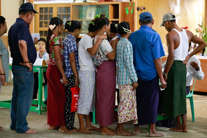 People line up as they wait to cast their votes for by-elections at a polling station of Hlaing Thar Yar township in Yangon, Myanmar, 01 April 2017. Photo: Lynn Bo Bo/EPA
