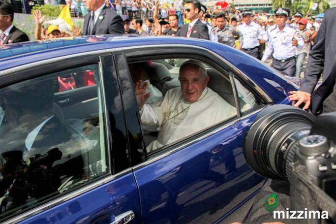  Pope Francis waves from inside a vehicle as as he is welcomed by the crowd along a road in Yangon on 27 November 2017. Photo: Thura/Mizzima
