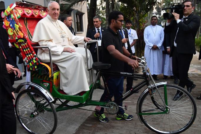 Pope Francis (L) arrives in a rickshaw at an Interreligious and Ecumenical meeting for peace at the garden of the Archbishop in Dhaka, Bangladesh, 01 December 2017. Photo: Ettore Ferrari/EPA-EFE
