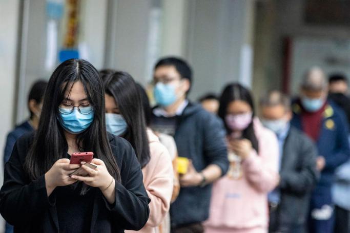 People queue outside a pharmacy as they won the lottery to buy protective masks, in Guangzhou, China, 13 February 2020. Photo: EPA