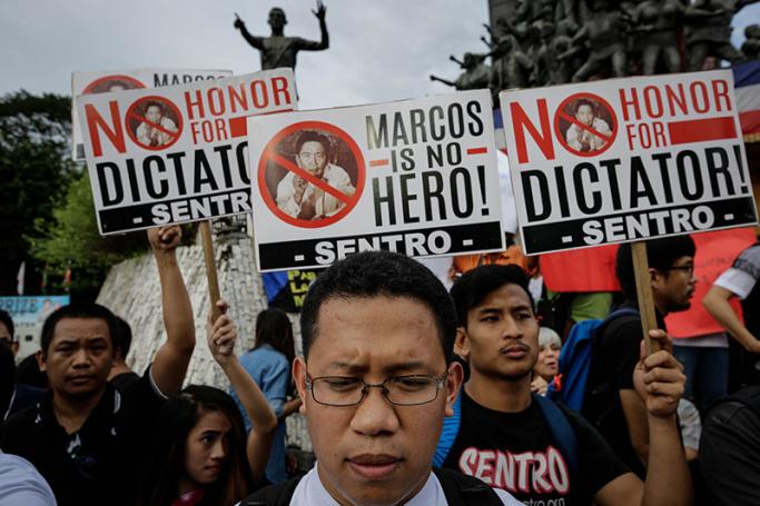 A Filipino priest (C) joins demonstrators holding placards during a protest against the burial of former dictator Ferdinand Marcos at the People Power Monument in Quezon City, northeast of Manila, Philippines, 18 November 2016. Photo: Mark R. Cristino/EPA
