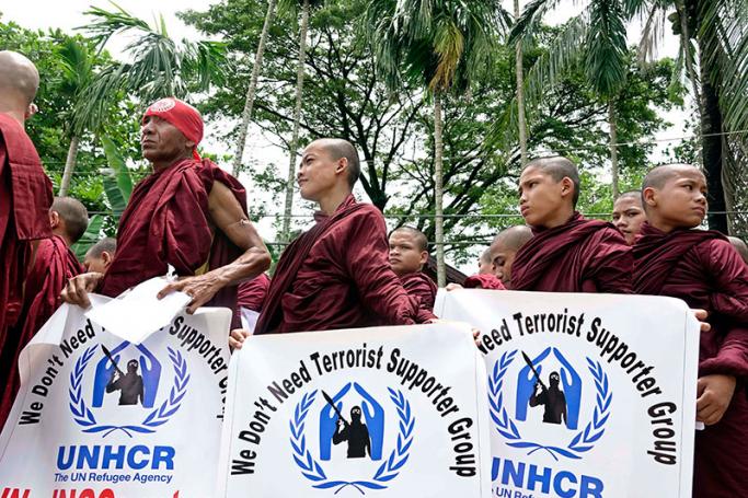 Buddhist monks hold placards during a protest against the United Nations (UN), international non-governmental organizations (INGOs) and NGOs in Sittwe, Rakhine State, western Myanmar, 13 August 2017. Photo: Nyun Win/EPA

