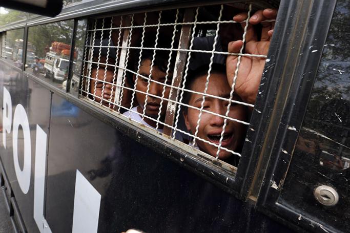 Protesting workers seen inside a police van after being arrested when they tried to march in a protest for labor rights in TetKone, near Naypyitaw, Myanmar, 18 May 2016. Photo: Hein Htet/EPA
