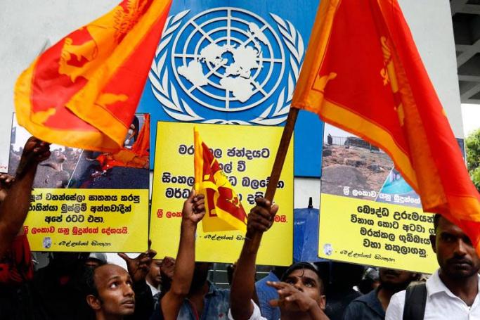 Protestors from a group claiming itself as the Sinhala Nidahas Satankamee Peramuna (Sinhala Independent Militants' Front) carrying distorted national flags protest in front of the United Nations office in Colombo, Sri Lanka, 27 September 2017. Photo: M.A. Pushpa Kumara/EPA
