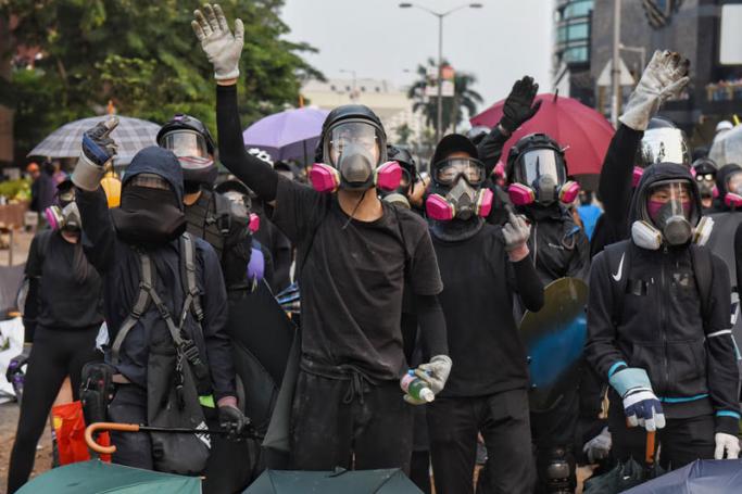 Protesters wearing gas masks cordon off the road near the Hong Kong Polytechnic University as they prepare to clash with police, in Hong Kong, China, 14 November 2019. Photo: EPA