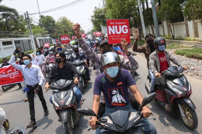 Demonstrators carry placards during an anti-military coup protest in Mandalay, Myanmar, 25 April 2021. Photo: EPA