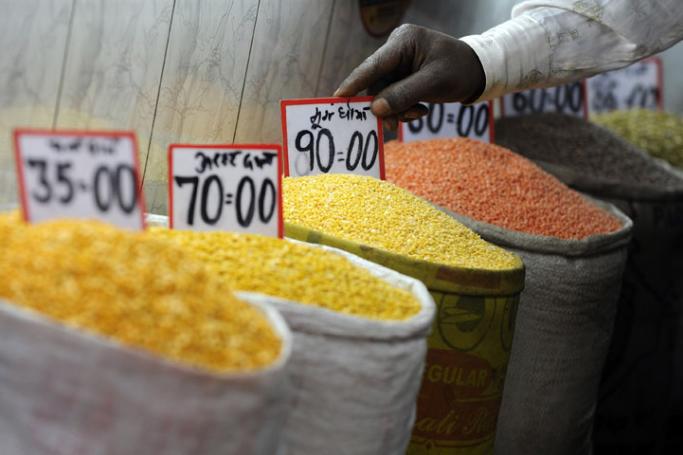 A shopkeeper arranges price tags on pulses at a wholesale market in the old quarter of New Delhi, India. Photo: Manan Vatsyayana/AFP
