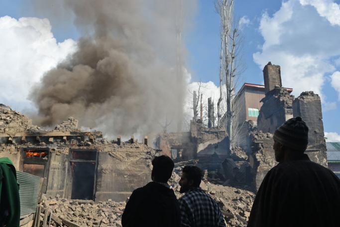 Kashmiri villagers look on a fire razes a house following a deadly gun battle between militants and Indian government forces in Tral area of Pulwama district, south of Srinagar, on March 5, 2019. Photo: Tauseef Mustafa/AFP