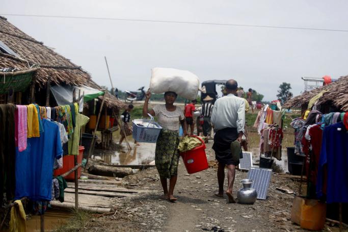 (File) A woman carries a bag as she walks near the Tin Nyo village's internally displaced persons (IDP) shelter in Mrauk U township area, Rakhine State, western Myanmar, 15 July 2019. Photo: Nyunt Win/EPA