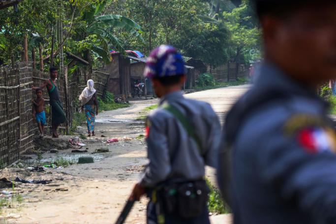 (File) This photo taken on September 6, 2017 shows Rohingya Muslims in the village of Shwe Zarr looking at Myanmar police, who are providing security due to recent nearby unrest, near Maungdaw township in Rakhine State. Photo: AFP
