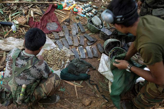 Rebels belonging to the Kachin Independence Army (KIA) ethnic group inspect government ammunitions and soldiers' helmets after two days of fighting with the Myanmar military near Laiza in Kachin State. Photo: AFP
