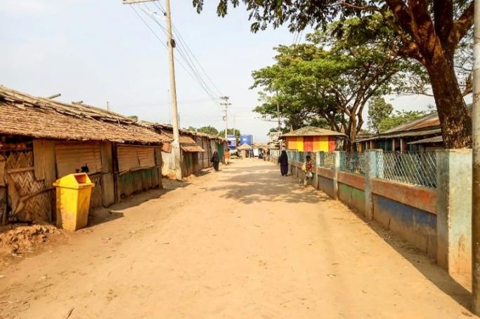 Rohingya refugees walk near closed shops on a deserted alley of a refugee camp during a government-imposed lockdown of Cox's Bazar district as a preventive measure against the COVID-19 coronavirus, in Ukhia on April 9, 2020. (AFP Photo/Mohammad Kalam) 