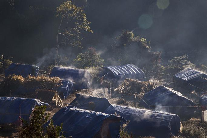 Refugees in front of their temporary shelter near Lung Byeng village, Waimaw township in Kachin state. Photo: Hkun Lat/AFP
