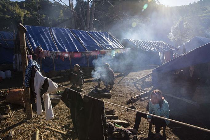 Internally displaced people in front of their temporary shelter near Lung Byeng village, Waimaw township in Kachin State. Photo: Hkun Lat/AFP
