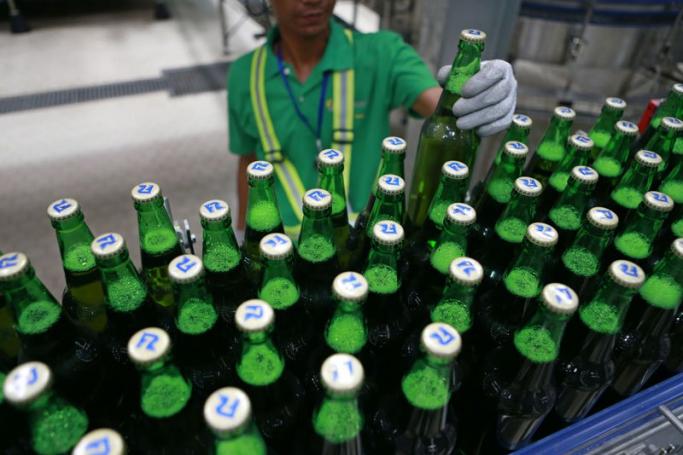 A worker inspects bottles of Regal Seven beer at Heineken's newly-opened brewery near Yangon, Myanmar, 12 July 2015. Photo: Lynn Bo Bo/EPA
