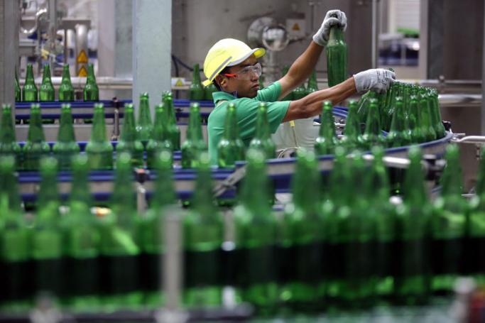 A worker inspects empty bottles of Regal Seven beer at Heineken's newly-opened brewery near Yangon. Photo: Lynn Bo BO/EPA
