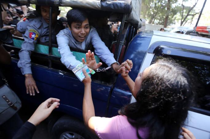 Detained Reuters journalist Kyaw Soe Oo calls to his wife outside court. Photo: Thet Ko for Mizzima
