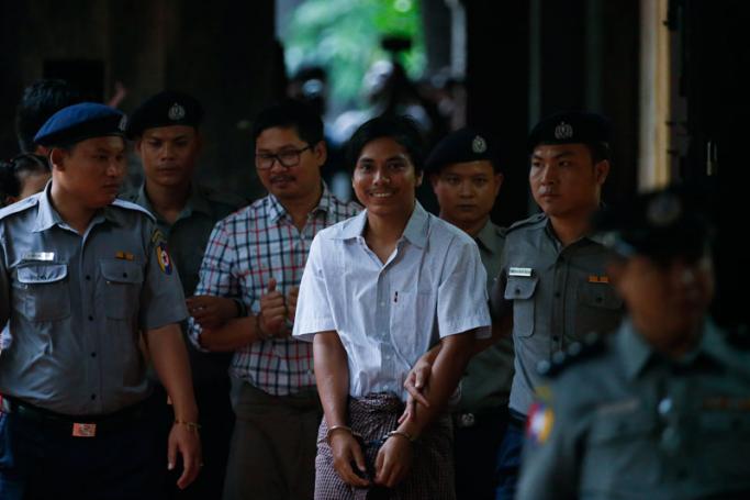 Detained Reuters journalist Kyaw Soe Oo (C), 28, is escorted by police as he arrives for the final argument of his trial at the court in Yangon, Myanmar, 20 August 2018. Photo: Lynn Bo Bo/EPA