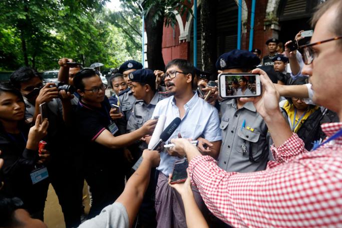 (File) Detained Reuter's journalist Wa Lone (C) talks to the media as he is escort out of court by police after a trial in Yangon, Myanmar, 09 July 2018. Photo: Nyein Chan Naing/EPA