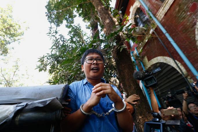 Reuters' journalist Wa Lone in handcuffs talks to the media as he leaves the court after the first trial in Yangon, Myanmar, 10 January 2018. Photo: Lynn Bo Bo/EPA-EFE
