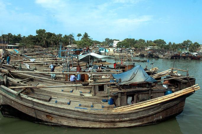 Bangladeshi fishermen tend to their anchored boats on the River Backhali in Cox's Bazar. Photo: AFP
