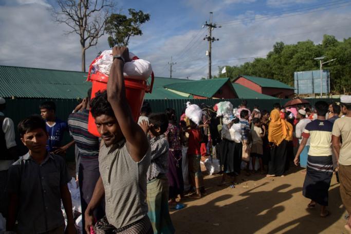 Rohingya refugees leave an aid relief distribution centre at the  Balukhali refugee camp near Cox's Bazar on August 12, 2018. Photo: Ed  Jones/AFP