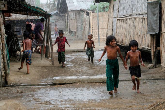 Rohingya children play during rain at an Internally Displaced Persons (IDPs) camp near Sittwe of Rakhine State, western Myanmar, 22 March 2016. Photo: Nyunt Win/EPA
