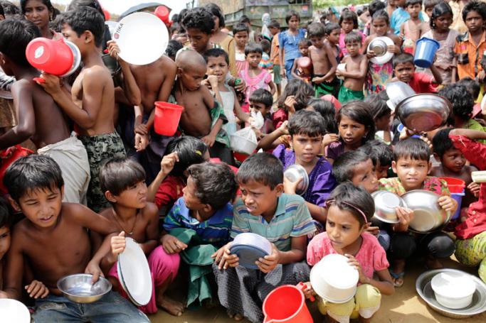 Rohingya children wait outside a food center to collect lunch time food in a camp in Palonkhali, Coxsbazar, Bangladesh, 11 October 2017. Photo: Abir Abdullah/EPA-EFE
