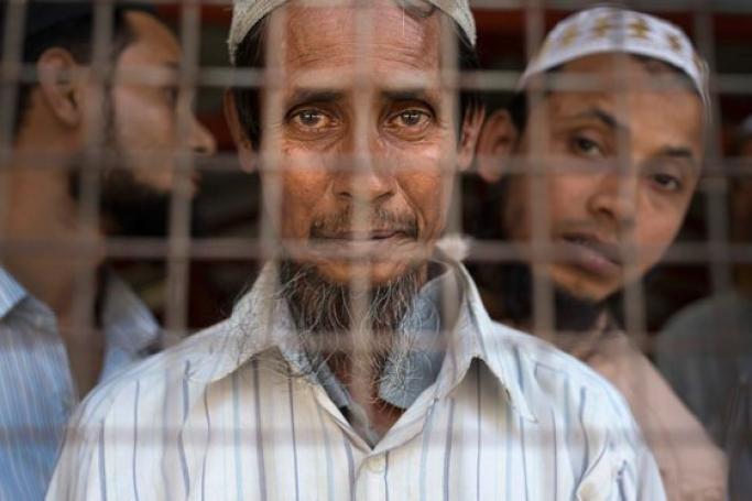 A Rohingya man looks out from behind the gate of a mosque near Sittwe, the capital of Rakhine State. Photo: Paula Bronstein/Getty Images Reportage for the United States Holocaust Memorial Museum
