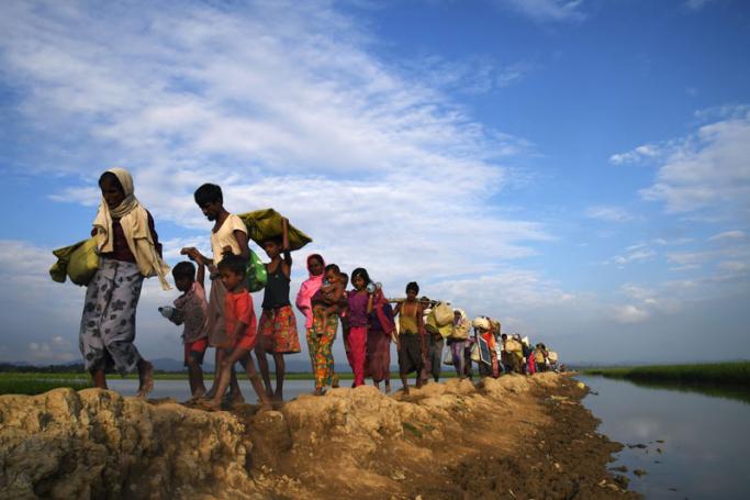 (FILES) In this file photo taken on November 2, 2017, Rohingya Muslim refugees who were stranded after leaving Myanmar walk towards the Balukhali refugee camp after crossing the border in Bangladesh's Ukhia district. Photo: Dibyangshu Sarkar/AFP
