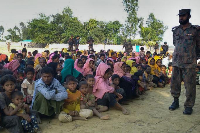 (Files) Rohingya Muslims from Myanmar, who tried to cross the Naf river into Bangladesh to escape sectarian violence, are kept under watch by Bangladeshi security officials in Teknaf on December 25, 2016. Photo: AFP
