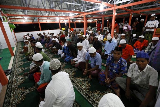 Rohingya Muslims migrants attend morning prayers during the first day of the fasting month of Ramadan, at a refugee camp in Bireun Bayeun, East Aceh, Aceh, Indonesia, 18 June 2015. Photo: Hotli Simanjuntak/EPA
