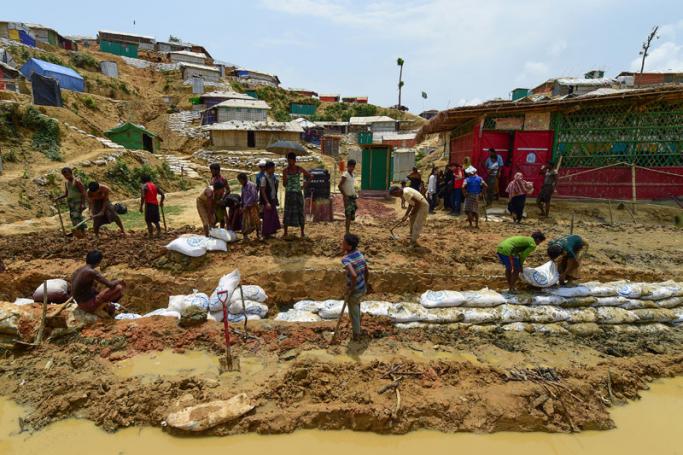 In this photograph taken on May 8, 2018, Rohingya refugees make a drainage canal in preparation for the upcoming monsoon season in Kutupalong refugee camp in Ukhia. For the 700,000 Rohingya Muslims who have fled to southeast Bangladesh in the past nine months, the approaching monsoon season poses the most serious threat since they were violently expelled from Myanmar. Photo: Munir Uz Zaman/AFP
