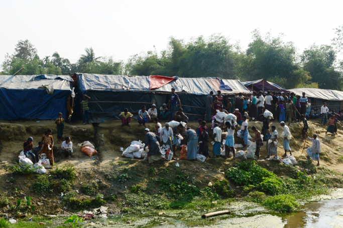 Rohingya refugees collect relief material next to a settlement near the 'no man's land' area between Myanmar and Bangladesh in Tombru in Bangladesh's Bandarban on February 27, 2018. Photo: Munir Uz Zaman/AFP
