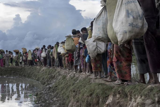 (FILES) In this file photo taken on October 9, 2017 Rohingya refugees walk after crossing the Naf river from Myanmar into Bangladesh in Whaikhyang. Photo: Fred Dufour/AFP
