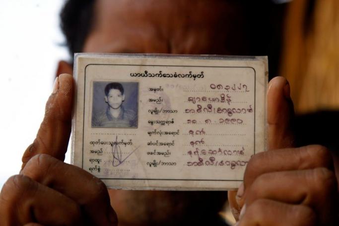 A Rohingya man shows his 'white card', a temporary registration document, before returning it to officials at the ThetKelPyin Muslim refugee camp in Sittwe, Rakhine State on April 3, 2015. Photo: Nyunt Win/EPA

