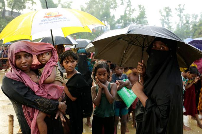 Rohingya refugees stand in queue during rain to collect relief goods near a center in Balukhali, in Coxsbazar, Bangladesh, 12 October 2017. Photo: Abir Abdullah/EPA-EFE
